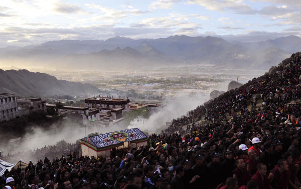 People wait for the unfolding ceremony of Sakyamuni Thangka painting during the Shoton Festival in Lhasa, Aug 29, 2011. [Photo/Xinhua] 