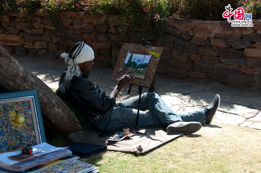 A self-employed painter paints the Union Buildings. [Maverick Chen / China.org.cn]