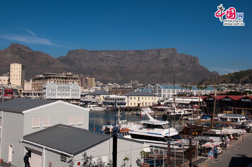 A harbour filled with yachts at the coastal city of Cape Town, South Africa. In the distance is a tourism attraction Table Mountain, renowned for its flat top. [Maverick Chen / China.org.cn]