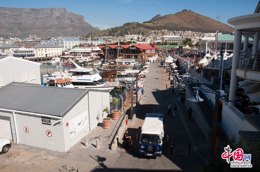 A harbour filled with yachts at the coastal city of Cape Town, South Africa. In the distance is a tourism attraction Table Mountain, renowned for its flat top. [Maverick Chen / China.org.cn]