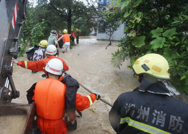 Firefighters help evacuate people trapped by floods in Xiaquan Village, Anji county, Zhejiang Province, August 30, 2011. Nanmadol landed in the Fujian Province's Jinjiang City at 2:20 am on Wednesday, packing a wind of 20 meters per second. [Xinhua photo]