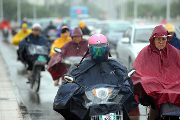 People ride their bicycles amid rains in Fuzhou, capital city of east China's Fujian Province Aug 31, 2011. Nanmadol landed in the province's Jinjiang City at 2:20 am on Wednesday, packing a wind of 20 meters per second. [Xinhua photo] 