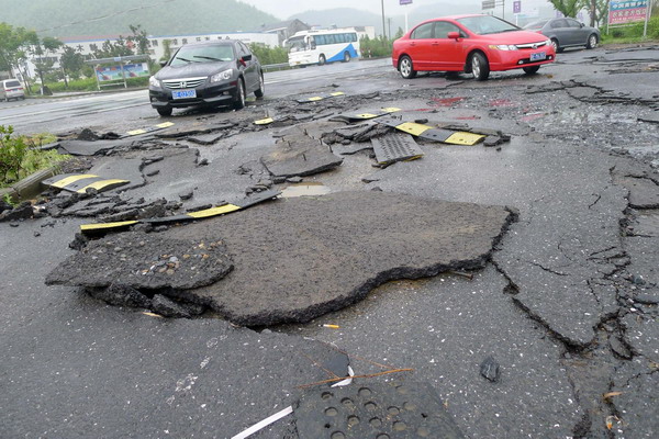 A road is destroyed by floods in Xiaquan village, Anji county, Zhejiang Province, Aug 30, 2011.