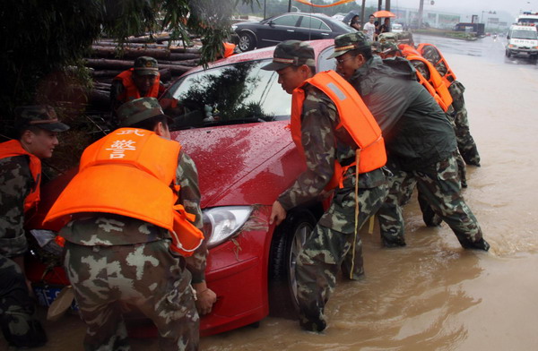 Soldiers help move a car trapped in floods in Baishuiwan village, Anji county, Zhejiang Province, Aug 30, 2011. 