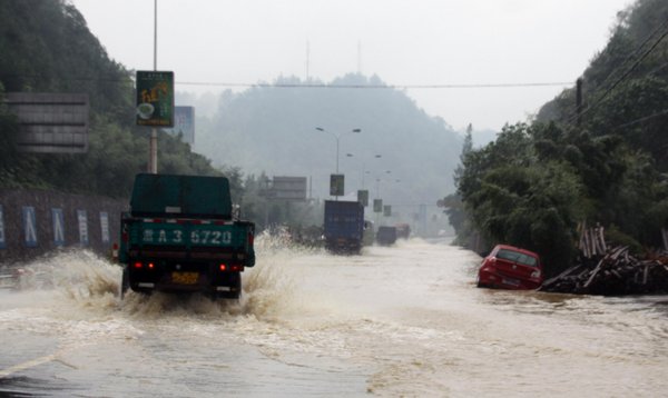 Vehicles drive through flooded streets in Anji county, Zhejiang Province, Aug 30, 2011. 