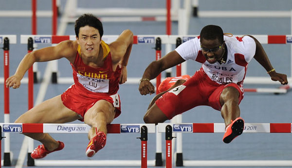 Cuba's Daron Robles(R), and China's Liu Xiang clear a gate as they compete in the men's 110m hurdles final at the World Athletics Championships in Daegu, South Korea, Monday, Aug. 29, 2011. Source:CFP