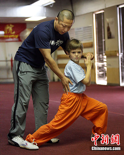 A Chinese teacher teaches an American boy martial arts in Huston. Martial arts, also known as wushu or kung fu, have become more and more popular in the United States over the past years. 