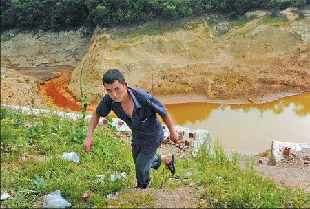 A pond in Qujing, Yunnan province, which was heavily contaminated by illegally dumped toxic industrial waste. [China Daily]