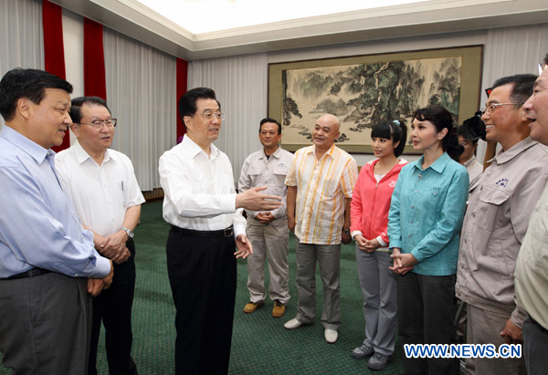 Chinese President Hu Jintao (3rd L) talks with performers of the stage play Guo Mingyi before he watches the performance in Beijing, capital of China, Sept. 2, 2011. Fifty-two-year-old Guo Mingyi donated half of his salary over the past 16 years to support 180 poor students in school. He was honored to be one of the top ten figures for 'Touching China', a public poll that selects the country's ten most inspiring individuals or groups. [Xinhua] 