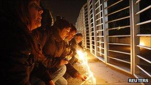 [People lit candles outside TVN television station after it reported that five of its staff were on board.] 