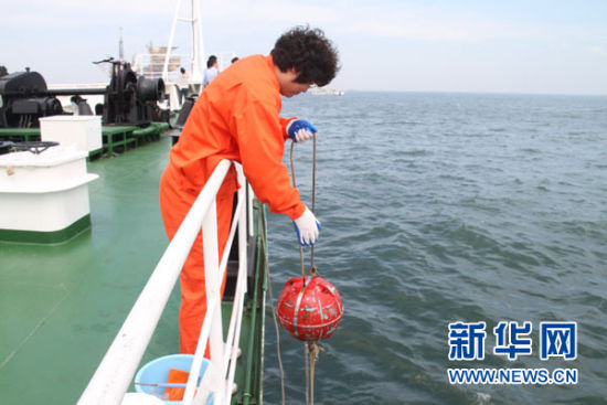 A worker from the state oceanic administration monitors the oil spill situation in north China's Bohai Bay on September 2, 2011. 