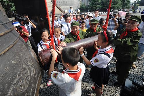 Veterans and primary school students ring a large bell 66 times to commemorate the anniversary of China's victory against the Japanese at the Memorial Hall for the Victims of the Nanjing Massacre in Nanjing, capital of east China's Jiangsu Province, on Saturday, September 3, 2011. [Photo: Xinhua] 