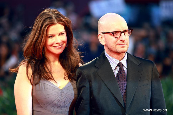 Director Steven Soderbergh and his guest walk on the red carpet for the premiere of the film 'Contagion' at the 68th Venice International Film Festival in Venice, Italy, on Sept. 3, 2011.
