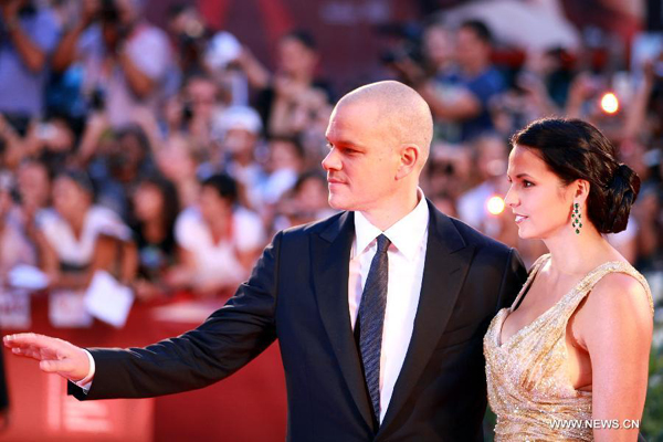 Actor Matt Damon and his wife walk on the red carpet for the premiere of the film 'Contagion' at the 68th Venice International Film Festival in Venice, Italy, on Sept. 3, 2011.