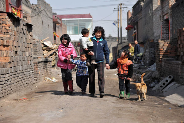 Li Yanping, a 45-year-old mother of 80 orphans picks up some of her children from school in Yaopu village, North China's Shanxi province, March 19, 2011.