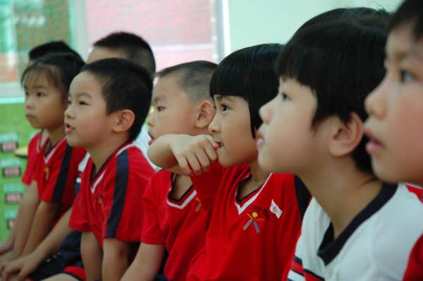 Children listen attentively during a mathematics class at Xiehe Kindergarten in Guangzhou on Sept 2. The school is reported to have asked parents to buy 27 items of uniform for each child. 