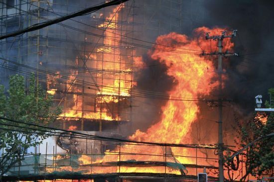 The 28-story building at the intersection of Jiaozhou Road and Yuyao Road in Jing'an District was being renovated when it caught fire at about 2 p.m. November 15, 2010.[File photo]