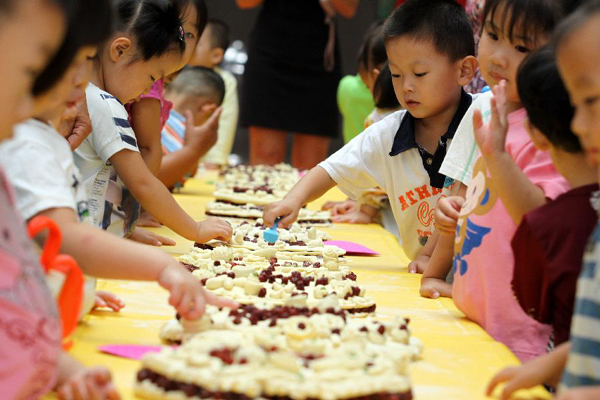 Children make moon cakes to celebrate the upcoming Mid-Autumn Festival in Beihai Kindergarten in Weifang, east China's Shandong Province, Sept. 7, 2011. Chinese people have the tradition to eat moon cakes on the Mid-Autumn Festival, which falls on Sept. 12 this year.
