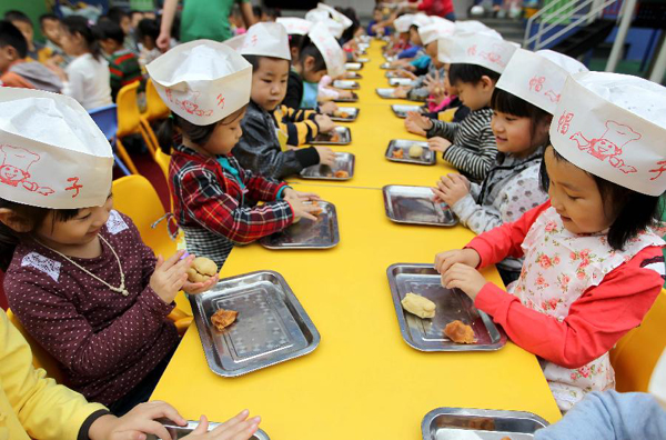 Children from a kindergarten make mooncakes in Yuncheng City, north China's Shanxi Province, Sept. 7, 2011. As the Mid-Autumn Festival is coming, children here made mooncakes to experience the traditional Chinese culture.