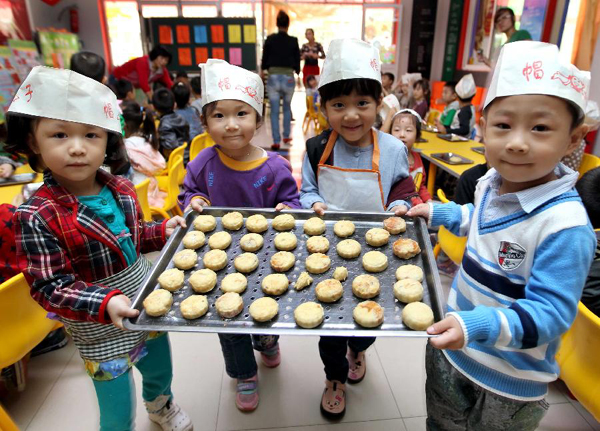 Children from a kindergarten show the mooncakes they made in Yuncheng City, north China's Shanxi Province, Sept. 7, 2011. As the Mid-Autumn Festival is coming, children here made mooncakes to experience the traditional Chinese culture.