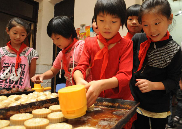 Children of migrant workers from a primary school make mooncakes in Liu'an City, east China's Anhui Province, Sept. 7, 2011. As the Mid-Autumn Festival is coming, children in many kindergartens made mooncakes to experience the traditional Chinese culture. 