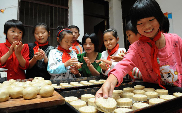 Children of migrant workers from a primary school make mooncakes in Liu'an City, east China's Anhui Province, Sept. 7, 2011. As the Mid-Autumn Festival is coming, children in many kindergartens made mooncakes to experience the traditional Chinese culture. 