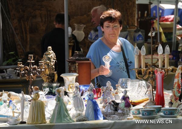 A woman shops at a sale stall during the annual 'Braderie de Lille', Europe's biggest flea market, in northern French city of Lille, on Sept. 3, 2011. [Xinhua/Wu Wei]