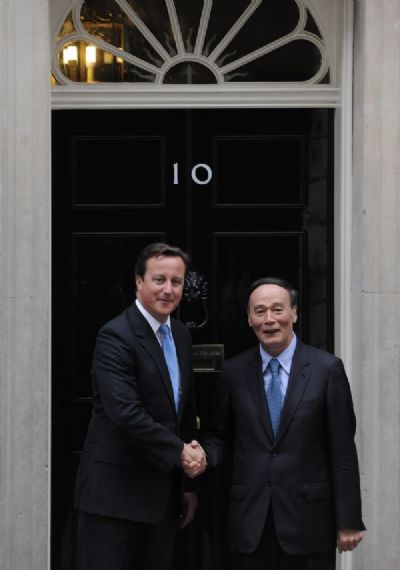 VVisiting Chinese Vice Premier Wang Qishan (R) shakes hands with British Prime Minister David Cameron in London, Britain, Sept. 8, 2011. [Zeng Yi/Xinhua]