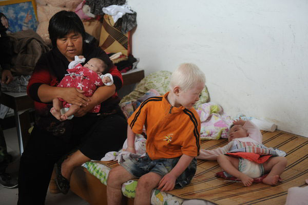 Yuan holds one of her adopted babies in Lankao county, Central China's Henan province, Sept 7, 2011. Over the years she has taken in many abandoned children.