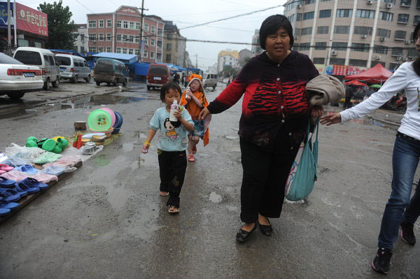 Yuan Lihai is followed by her adopted children in Lankao county, Central China's Henan province, Sept 7, 2011.