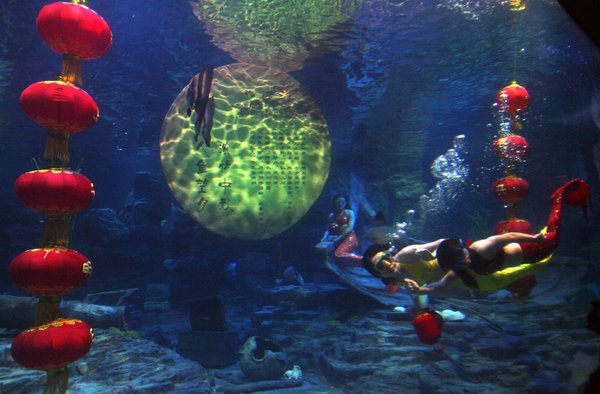 Mermaids swim around the 'full moon' and red lanterns to greet the upcoming Mid-Autumn Festival in Donghu Ocean World of Wuhan, capital of Central China's Hubei province, Sep.9, 2011. [CFP Photo]