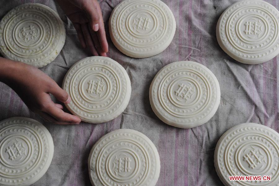 A villager makes moon cakes in a village of Yuncheng City, north China's Shanxi Province, Sept. 10, 2011. The steamed moon cakes made by local people in a traditional way as handmade wheaten food are popular as the Mid-Autumn Festival, which falls on Sept. 12 this year, is approaching. [Gao Xinsheng/Xinhua]