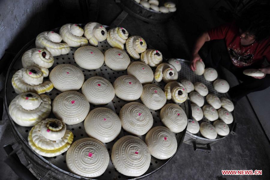 Photo taken on Sept. 10, 2011 shows moon cakes made by villagers themselves in a village of Yuncheng City, north China's Shanxi Province, Sept. 10, 2011. The steamed moon cakes made by local people in a traditional way as handmade wheaten food are popular as the Mid-Autumn Festival, which falls on Sept. 12 this year, is approaching. [Gao Xinsheng/Xinhua]