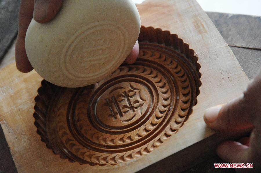 A villager makes moon cakes in a village of Yuncheng City, north China's Shanxi Province, Sept. 10, 2011. The steamed moon cakes made by local people in a traditional way as handmade wheaten food are popular as the Mid-Autumn Festival, which falls on Sept. 12 this year, is approaching. [Gao Xinsheng/Xinhua]