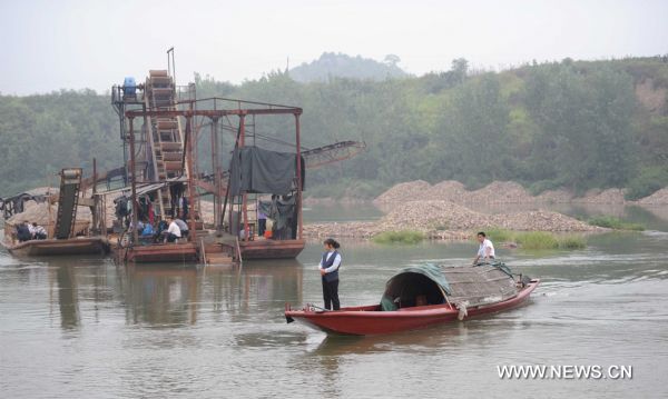 A boat passes by the scene of a ferry sinking accident in a river in Shaoyang County, central China's Hunan Province, Sept. 10, 2011. At least 11 people, mostly students from primary and middle schools, died and 16 others were injured after a ferryboat capsized and sank in the river on Friday afternoon. [Li Ga/Xinhua]