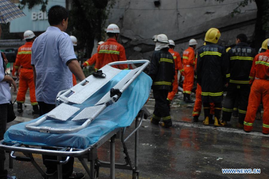 Rescuers work at the accident site of a collapsed shopping mall in Xi'an, capital of northwest China's Shaanxi Province, Sept. 11, 2011. Parts of a shopping mall which has been closed down collapsed Sunday morning. [Li Yibo/Xinhua]