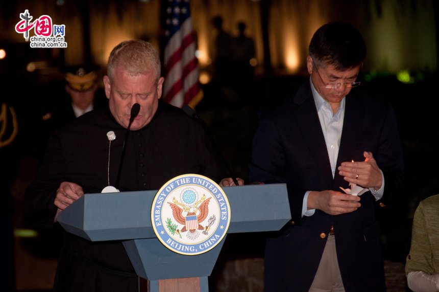 Gary Locke, US ambassador to China holds a candle as a priest is conducting a praying session for the victims killed in the attacks. [Pierre Chen / China.org.cn]