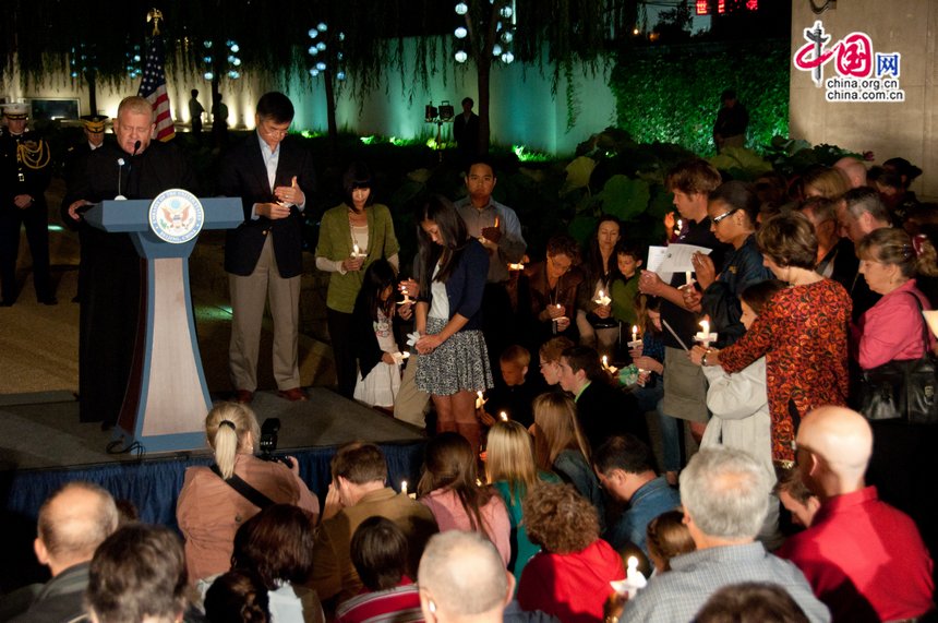 Gary Locke, US ambassador to China holds a candle as a priest is conducting a praying session for the deceased in the attacks. [Pierre Chen / China.org.cn]