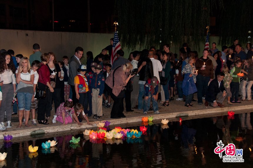 At the commemoration ceremony, people set off lotus lanterns in a pond as a means to show their emotions for the deceased lives in the 9/11 attacks. [Pierre Chen / China.org.cn]