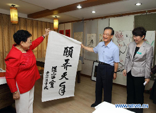 Chinese Premier Wen Jiabao gives his calligraphy work reading as Live An Easy Life in Old Age to a welfare home in Beijing, capital of China, Sept. 12, 2011. 