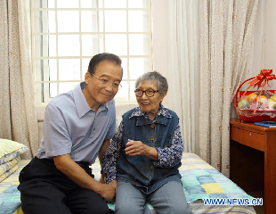 Chinese Premier Wen Jiabao talks to 91-year-old Shen Quan at a welfare home in Beijing, capital of China, Sept. 12, 2011. 