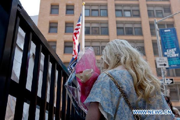 A visitor holds a bounch of flowers outside the 9/11 Memorial in New York, the United States, Sept. 12, 2011. [Fan Xia/Xinhua]