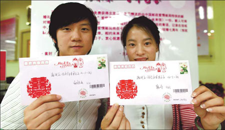  couple of newlyweds prepare to put love letters into a mailbox at a post office in Beijing's Haidian district on Sept 9. The letters will arrive at their home in seven years' time.[China Daily]