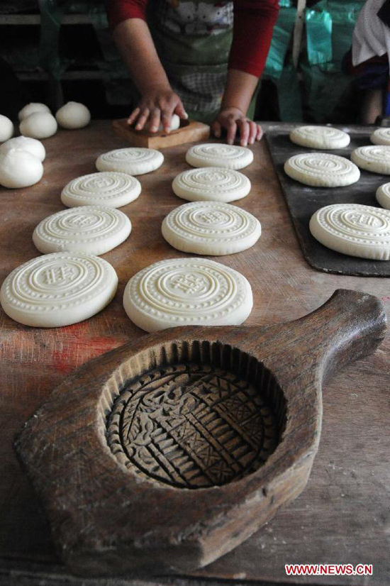 A villager makes moon cakes in a village of Yuncheng City, north China's Shanxi Province, Sept. 10, 2011. The steamed moon cakes made by local people in a traditional way as handmade wheaten food are popular as the Mid-Autumn Festival, which falls on Sept. 12 this year, is approaching.