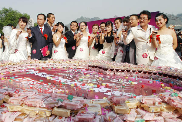 Newely weds raise the glasses in Gansu province on Sept 12, 2011. 100 couples tied the knot in a group wedding in Gansu province on Sept 12, this year's Mid-Autumn Festival.[Photo/Xinhua] 