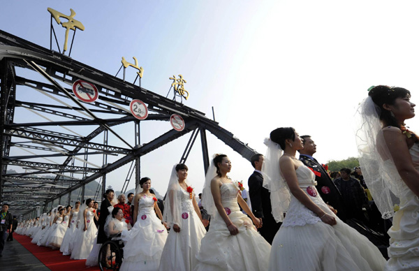 Newlyweds walk through the Zhonshan Bridge on Sept 12, 2011. 100 couples tied the knot in a group wedding in Gansu province on Sept 12, this year's Mid-Autumn Festival.[Photo/Xinhua]