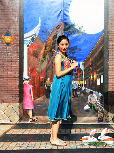 A woman poses in front of 3D art wall in Fuzhou of Fujian province, Sept 12, 2011. This year's Mid-Autumn Festival fell on Sept 12. [Photo/Xinhua] 