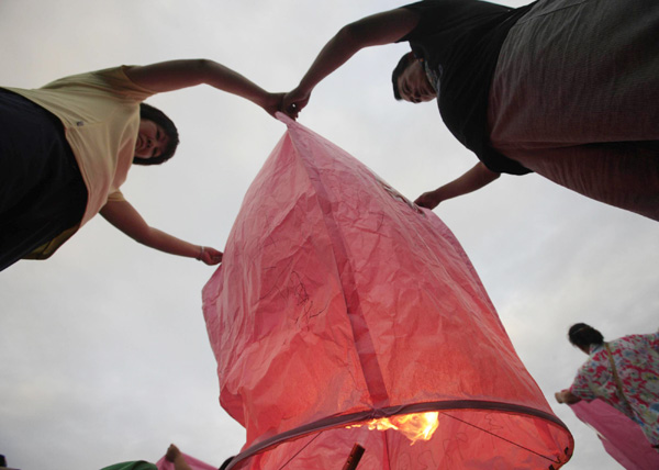 Visitors light up a lantern to celebrate the Mid-Autumn Festival in northern Taiwan province, Sept 12, 2011. [Photo/Xinhua] 