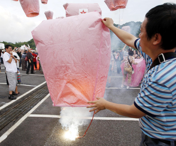 Visitors light up a lantern to celebrate the Mid-Autumn Festival in northern Taiwan province, Sept 12, 2011. [Photo/Xinhua]