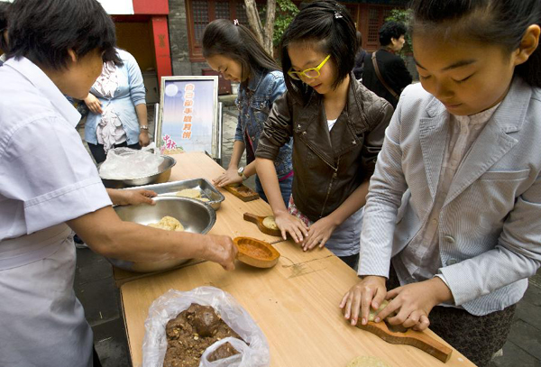 Students learn to make mooncakes at the Dongyue Temple in Beijing on Sept. 12, 2011, to celebrate the traditional Mid-autumn festival. Chinese people have the tradition to eat mooncakes on the Mid-Autumn Festival.
